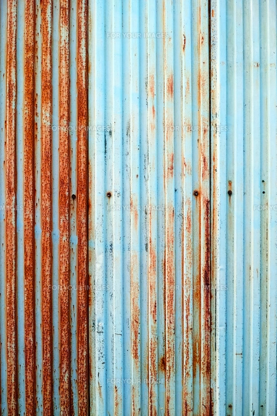 塗装が剥げた古い波鉄板のフェンスの写真素材 [FYI01223094
