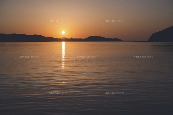 佐賀県唐津市呼子の海に沈む夕日と夕焼けの写真素材 [FYI04880867