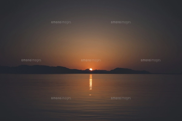 佐賀県唐津市呼子の海に沈む夕日と夕焼けの写真素材 [FYI04880867