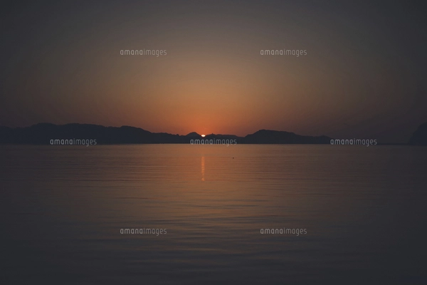 佐賀県唐津市呼子の海に沈む夕日と夕焼けの写真素材 [FYI04880867