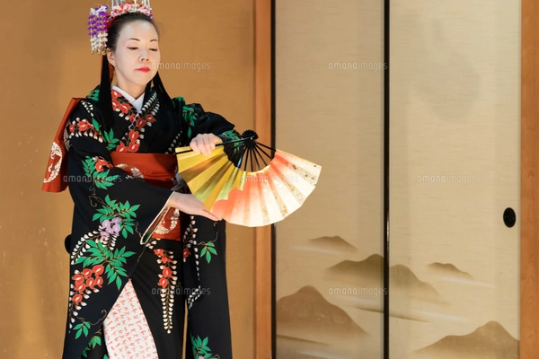 着物姿で扇子を持って日本舞踊を踊る若い日本人女性の写真素材