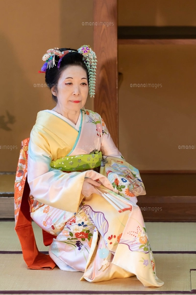 着物姿で扇子を持って日本舞踊を踊る年配の日本人女性の写真素材