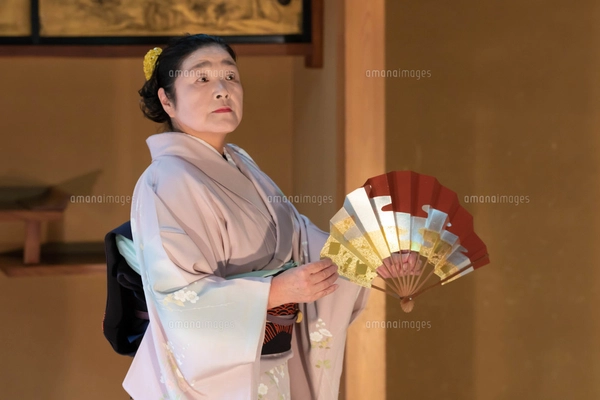 着物姿で扇子を持って日本舞踊を踊る年配の日本人女性の写真素材