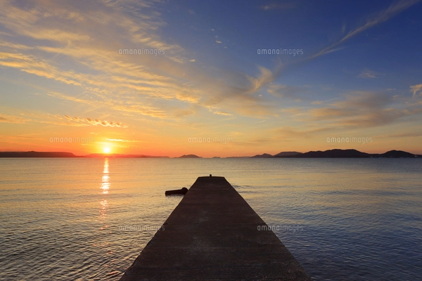 吉野崎自然海浜保全地区の堤防と夕日の写真素材 [FYI07521510