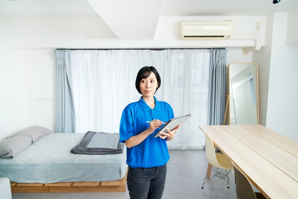 部屋を確認する作業着姿の女性の写真素材 [FYI07783603] | ストック 