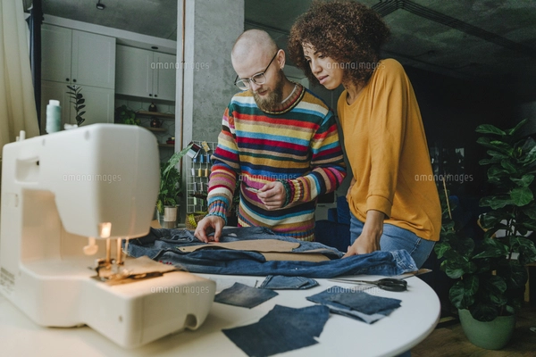 Multiracial male and female fashion designers huddling with clenched ...