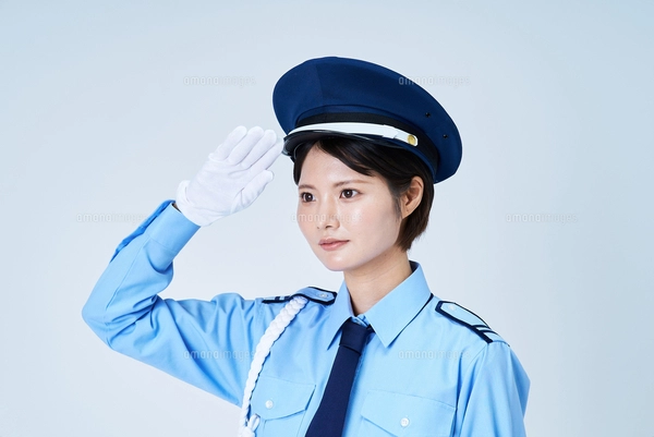 警備員の制服を着て、敬礼をする女性の写真素材 [FYI08134437